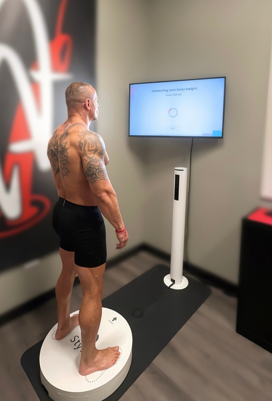 Member standing on the Styku 3D body scanning platform at the studio